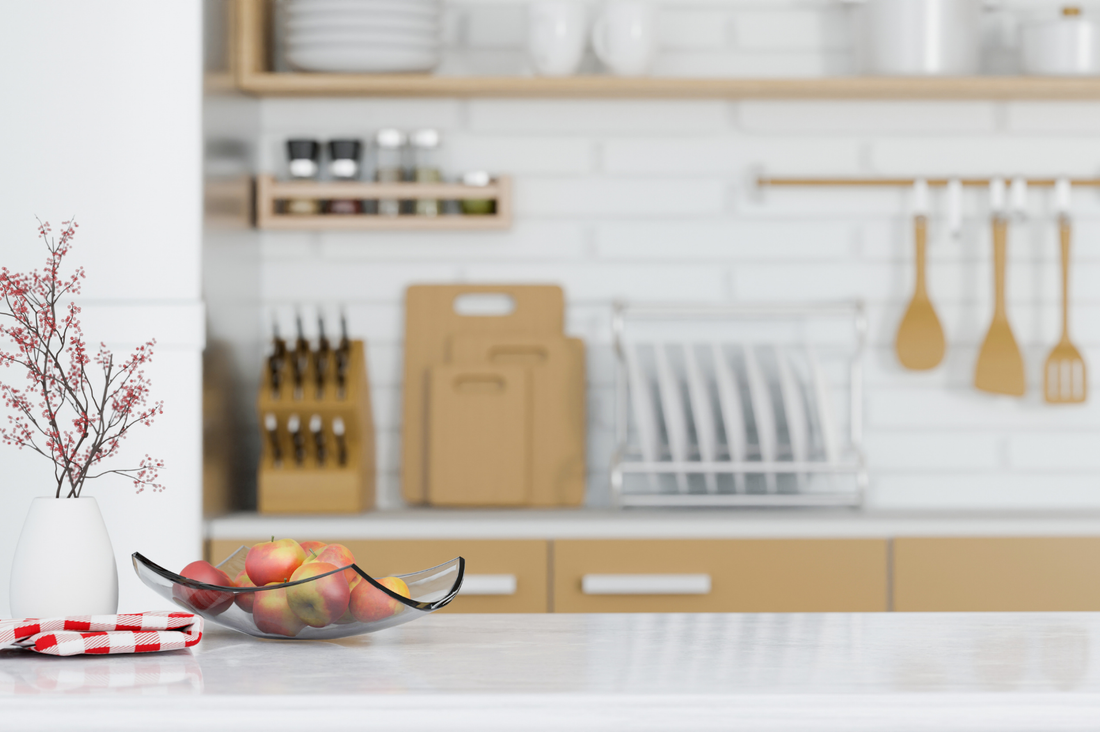 Décor de cuisine avec un bol de fruits sur le plan de travail et des ustensiles à l'arrière-plan