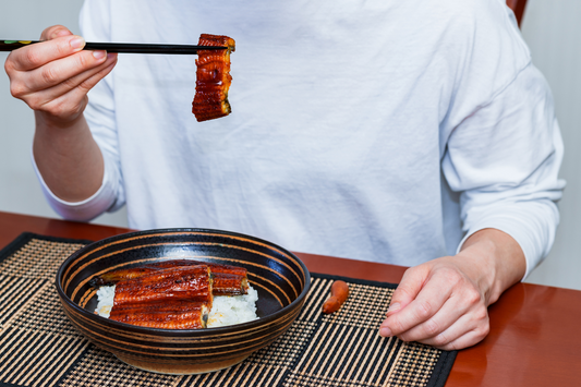 Personne mangeant de l'anguille sur du riz à la maison
