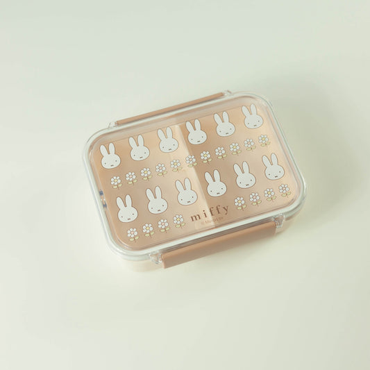 Pink lunch box with white bunny patterns on a light beige background