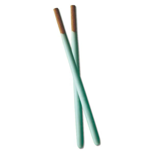Two green Pocky with brown tips on a white background